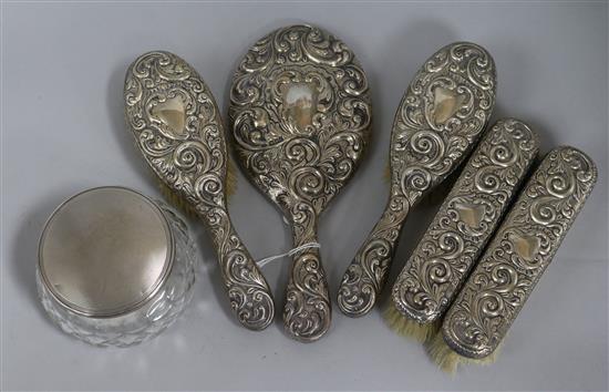 A five piece silver mounted mirror and brush set and a similar powder jar.